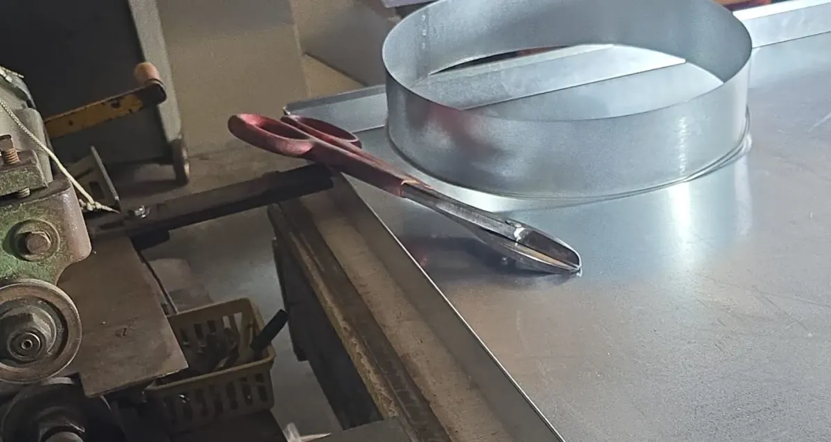 Custom-fabricated metal ring and tin snips on workbench